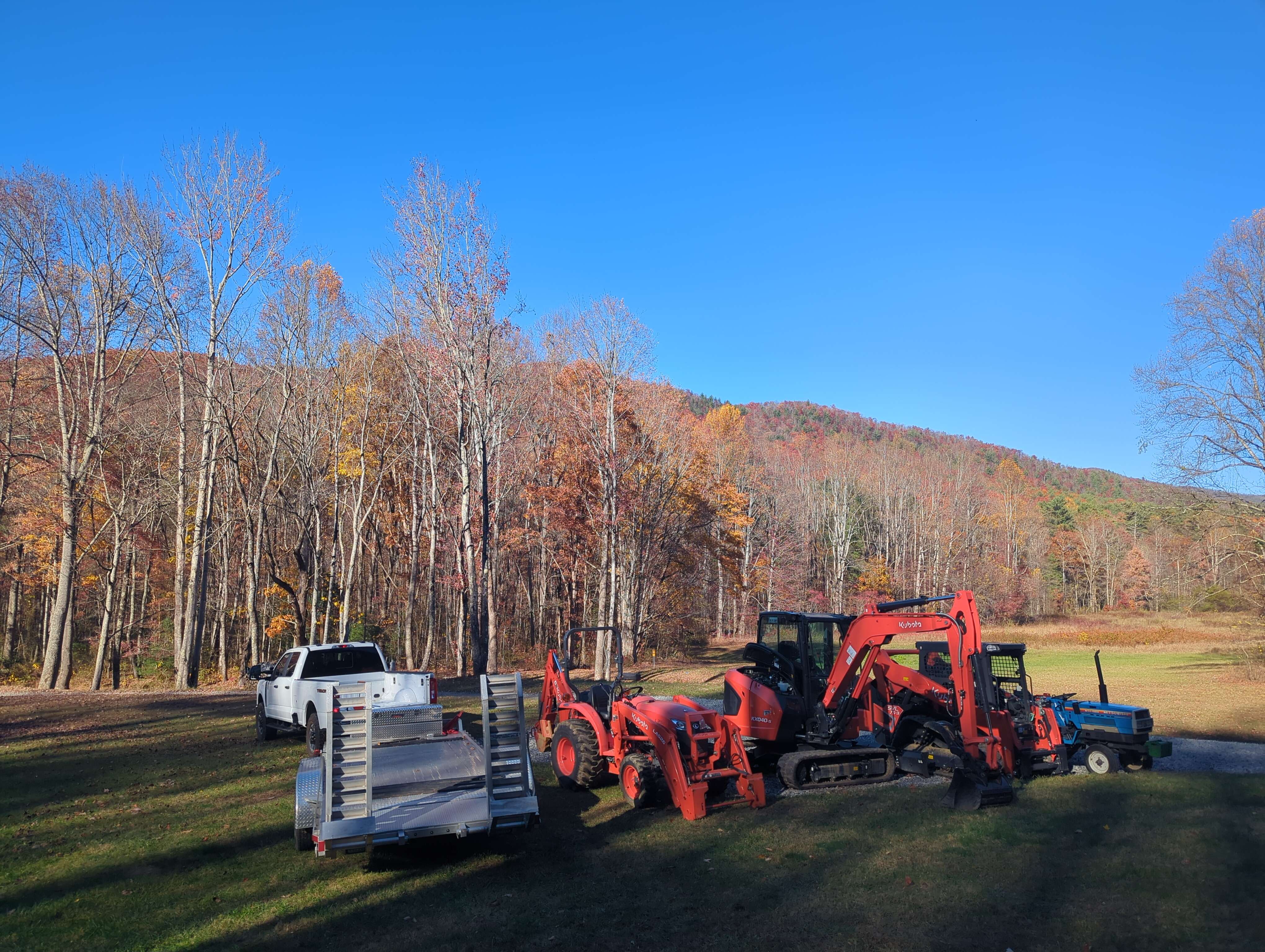Red farm tractors and trailer parked in autumn forest landscape